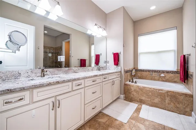 a bathroom with a granite countertop sink mirror and a bathtub