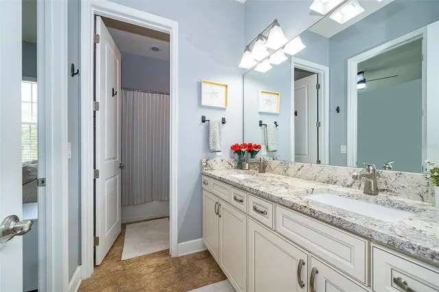 a bathroom with a granite countertop sink and a mirror