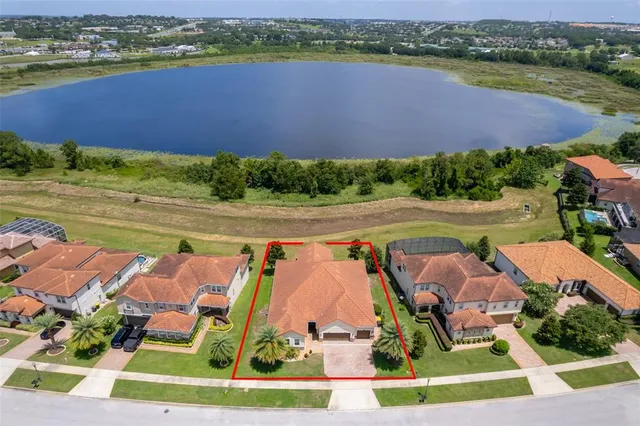 an aerial view of residential houses with outdoor space and lake view