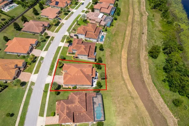 an aerial view of residential house with pool and trees