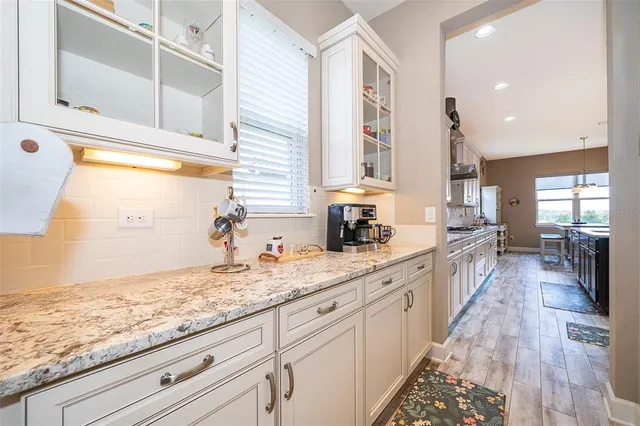 a large kitchen with kitchen island granite countertop white cabinets and sink