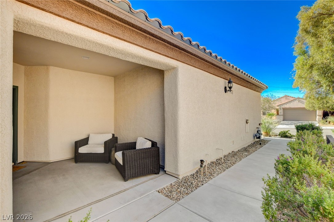 2649 Rue Marquette Avenue Henderson, NV 89044 - Photo 6 of 55 A welcoming covered porch with a tiled roof provides a cozy outdoor sitting area at the home's entrance.