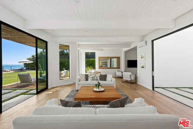 a living room with fireplace furniture and a large window