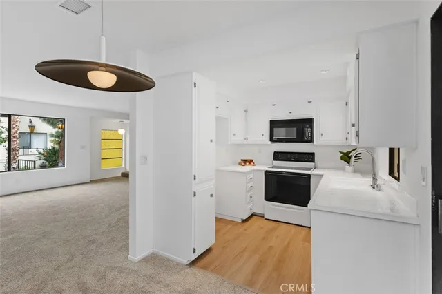 a kitchen with a refrigerator and a stove top oven