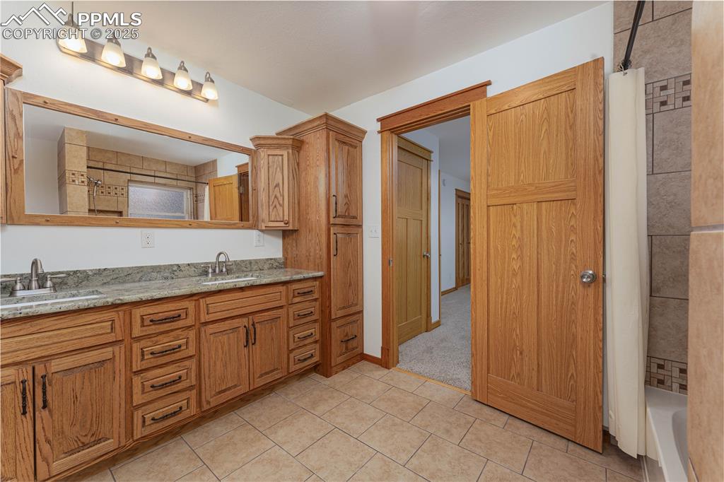 1075 8th Street Calhan, CO 80808 - Photo 12 of 45 a spacious bathroom with a granite countertop sink a mirror and a shower