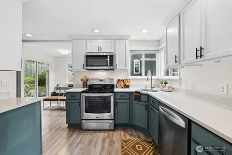 a kitchen with a sink stove top oven and microwave