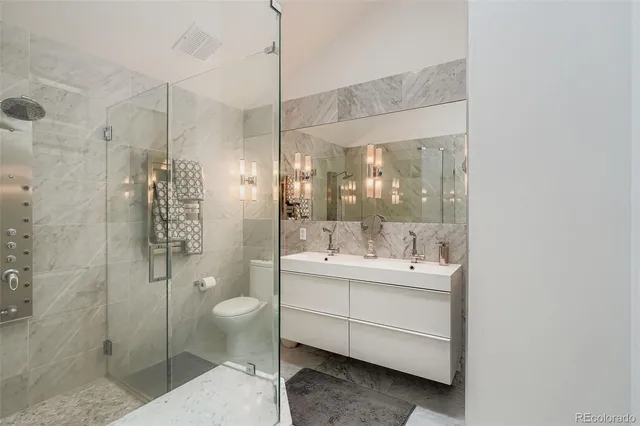 a bathroom with a double vanity sink toilet and shower