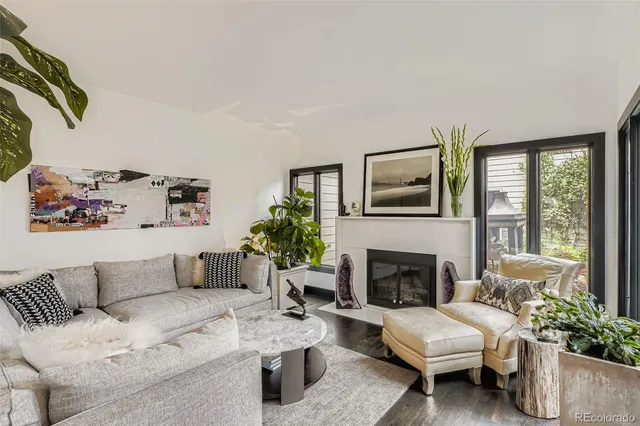 a living room with furniture fireplace and a large window