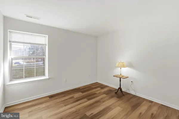 a view of empty room with wooden floor and window