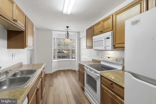 a kitchen that has a sink a stove and wooden floor