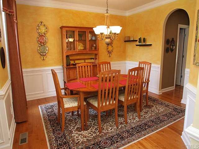8316 Clarks Branch Drive Raleigh, NC 27613 - Photo 3 of 12 Extensive moldings, gorgeous wide-plank hardwoods and archway to Butler's Pantry are all found here.