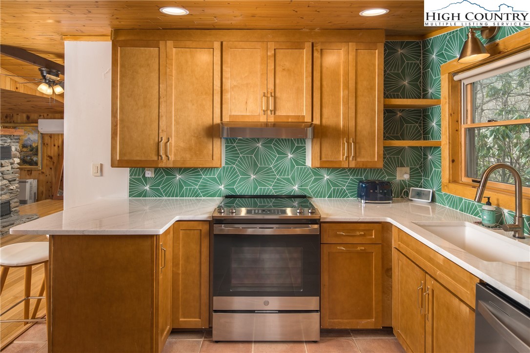 280 Chinkapin Ridge Road Seven Devils, NC 28604 - Photo 15 of 36 a kitchen with stainless steel appliances granite countertop a sink a stove and a microwave