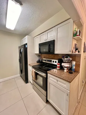 a kitchen with stainless steel appliances a stove a microwave and a refrigerator