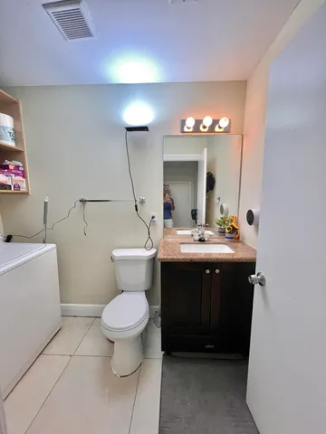 a bathroom with a toilet sink and mirror