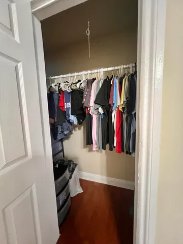 a view of walk in closet with clothes