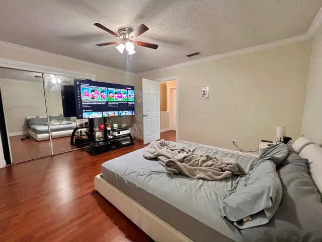 a bed room with a bed a television and a couch