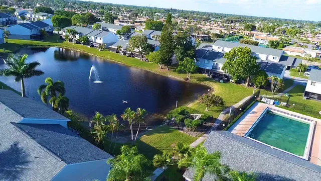 an aerial view of a house with a garden and lake view