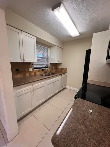 a kitchen with a sink a stove and cabinets