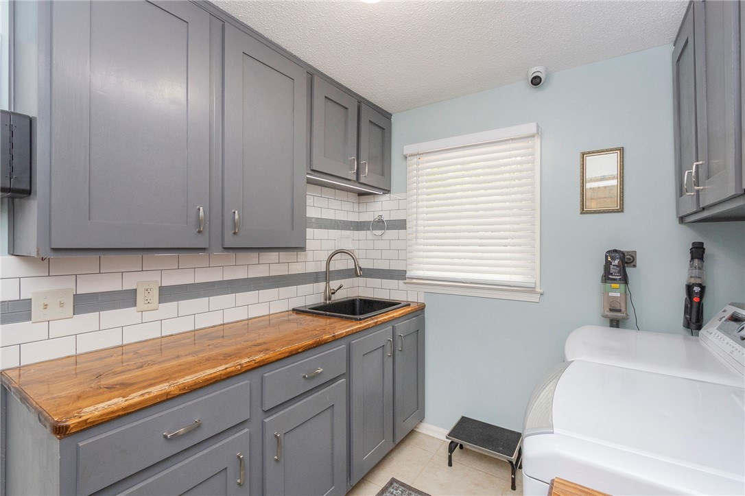 203 Oak Hollow Pendleton, SC 29670 - Photo 17 of 50 Functional utility room with ample cabinetry, warm wooden counters, and a convenient sink.