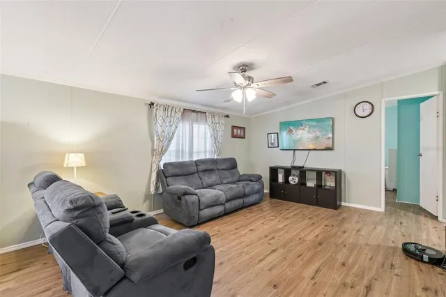 a living room with furniture and a ceiling fan