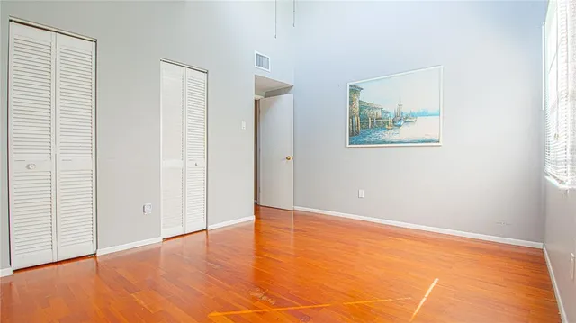 an empty room with wooden floor and window