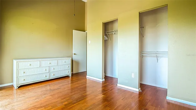 an empty room with wooden floor and cabinet