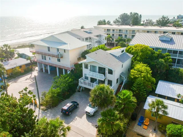 an aerial view of multiple houses with a yard