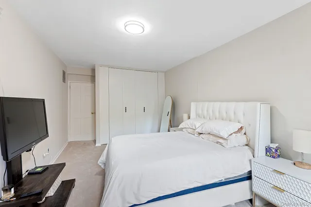 a bedroom with a bed and a flat screen tv