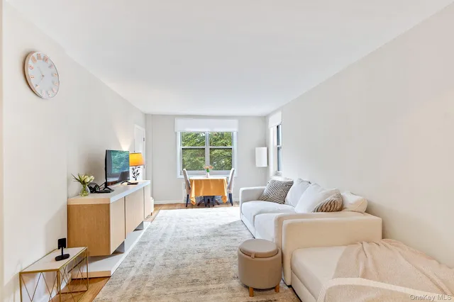 a living room with furniture a flat screen tv and a window