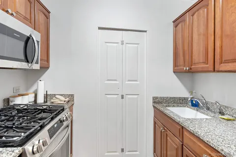 a kitchen with granite countertop a sink stove and cabinets