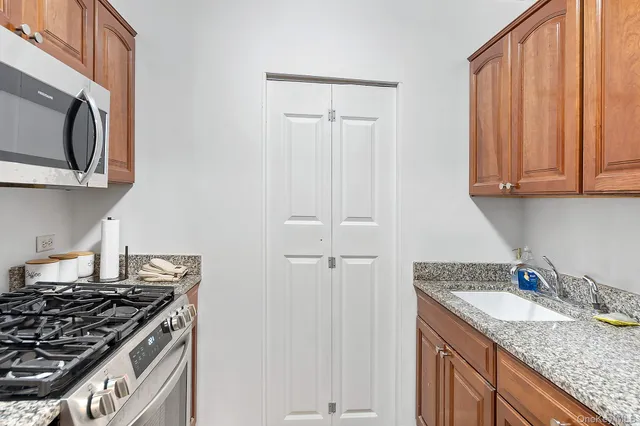 a kitchen with granite countertop a sink stove and cabinets