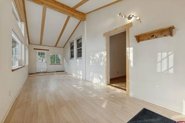 a view of a big room with wooden floor and windows