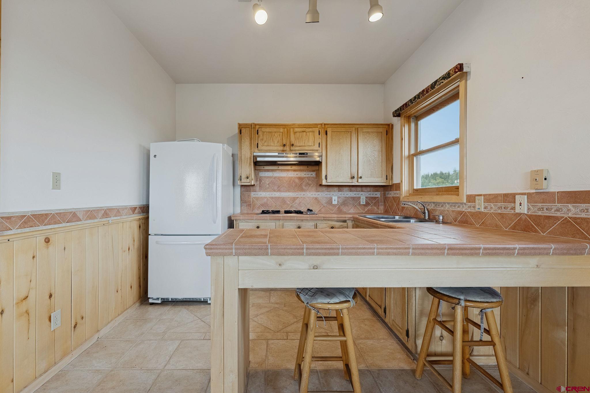 481 Far View Road Durango, CO 81303 - Photo 25 of 44 a kitchen with a table chairs refrigerator and cabinets
