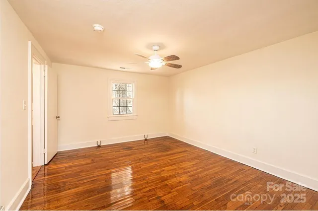 a view of a room with wooden floor and a ceiling fan