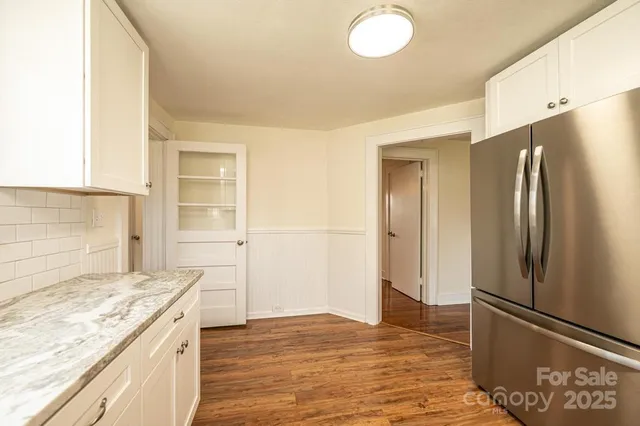 a kitchen with stainless steel appliances granite countertop a refrigerator and a stove