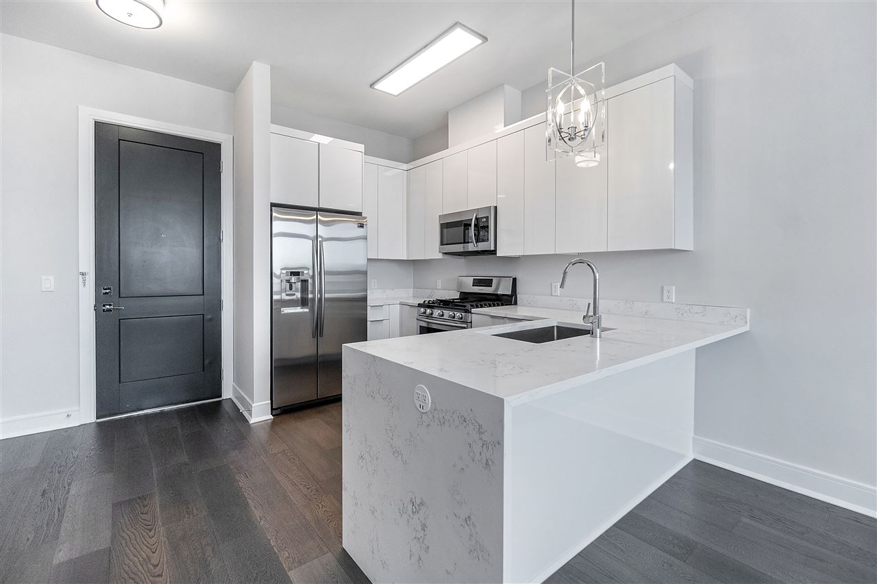a kitchen with kitchen island a refrigerator stove and sink