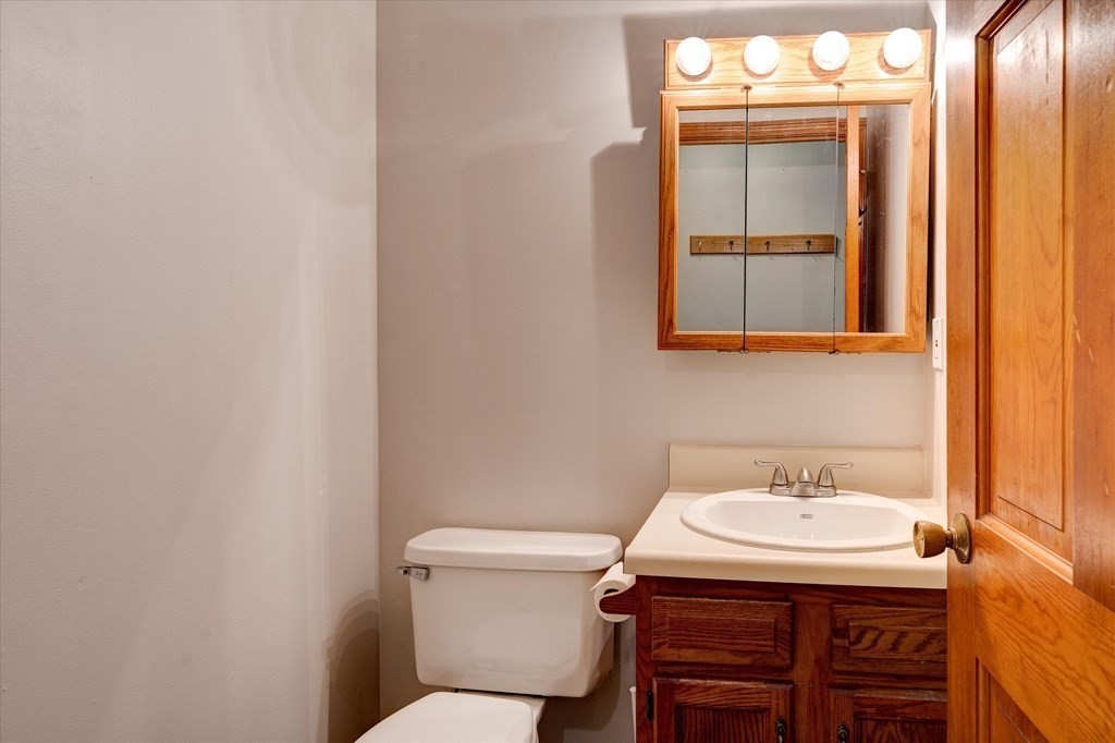 6 Litchfield Road, Unit A Londonderry, NH 03053 - Photo 11 of 28 a bathroom with a sink a toilet and mirror