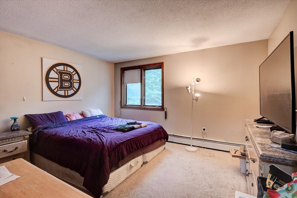 6 Litchfield Road, Unit A Londonderry, NH 03053 - Photo 15 of 28 a bedroom with a bed and a chandelier