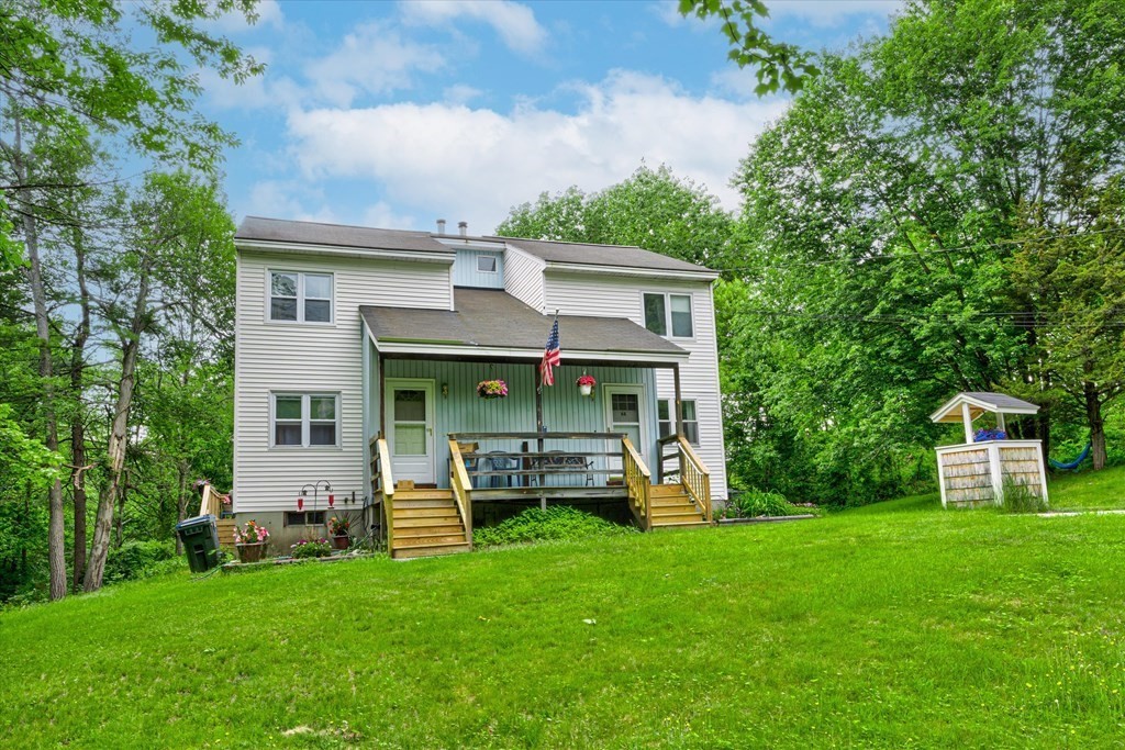 6 Litchfield Road, Unit A Londonderry, NH 03053 - Photo 26 of 28 a front view of a house with a garden and trees