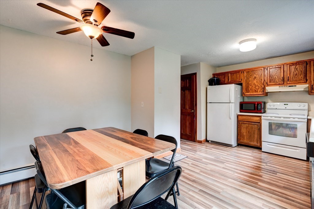 6 Litchfield Road, Unit A Londonderry, NH 03053 - Photo 8 of 28 a dining room with a table chairs and refrigerator