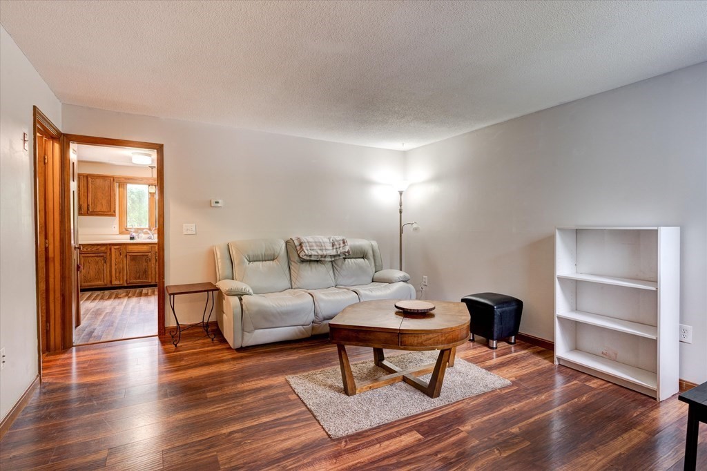 6 Litchfield Road, Unit A Londonderry, NH 03053 - Photo 10 of 28 a living room with furniture and a wooden floor