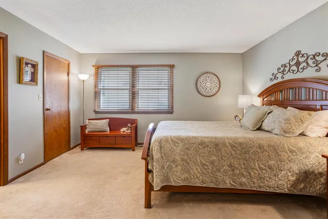 a bedroom with a bed a mirror and paintings on the wall