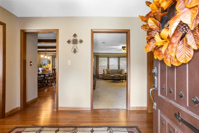 a view of a hallway view with wooden floor and living room