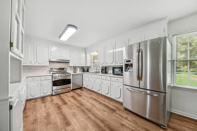 a kitchen with stainless steel appliances a refrigerator sink and microwave