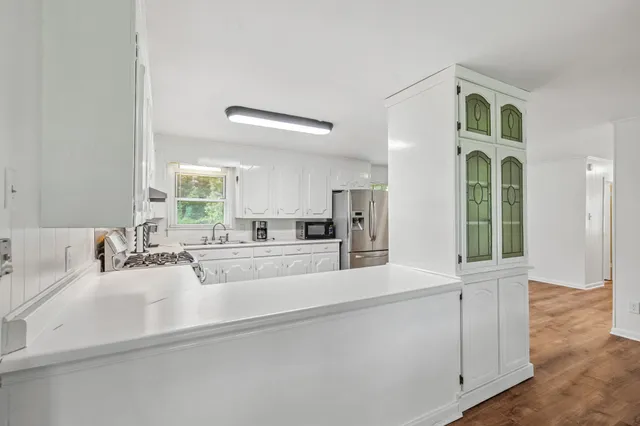 a large white kitchen with sink and window