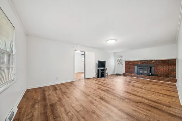 a view of an empty room with a fireplace and a window