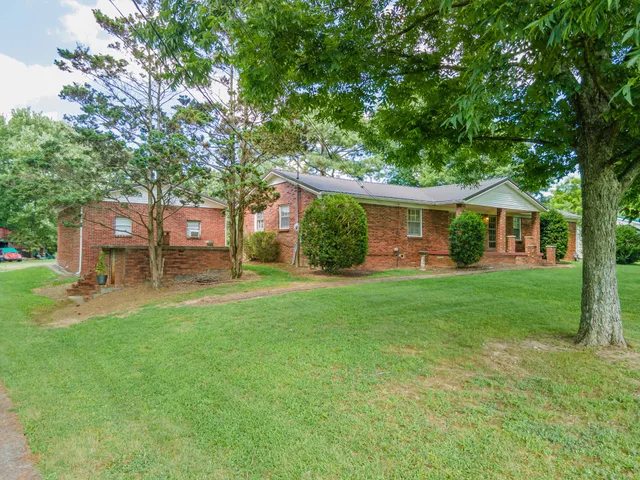 a view of a house with a yard and sitting area