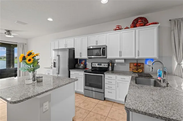 a kitchen with stainless steel appliances granite countertop a sink dishwasher and cabinets with wooden floor