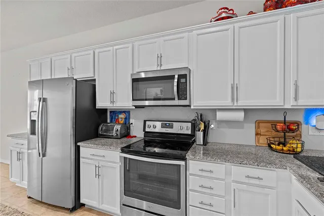 a kitchen with granite countertop white cabinets stainless steel appliances and sink