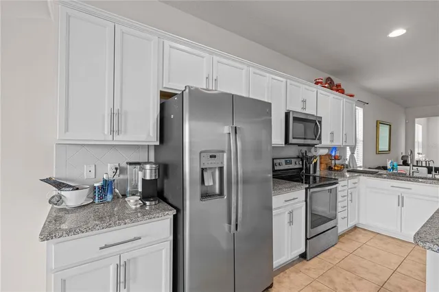 a kitchen with stainless steel appliances granite countertop a refrigerator sink and microwave